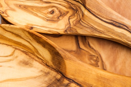 Close up of Kitchen Utensils from Olive Wood, such as Chopping Board and Salad Servers Set, light background, top view, texture, macro shot, shallow DOFの写真素材