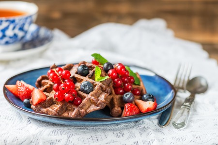Homemade Chocolate Belgium Waffles with strawberries, blueberries and redcurrants on Blue Plateの写真素材