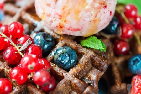 Chocolate Belgium Waffles with strawberries, blueberries, redcurrants with homemade strawberry ice cream scoop on top, close up of details, macro shotの写真素材