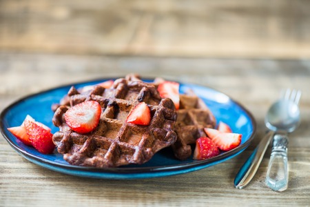 Homemade Chocolate Belgium Waffles with Strawberries on Blue Plateの写真素材