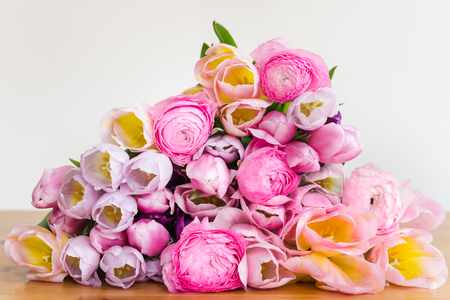 Close up of Bunch of Colorful Tulips and Pink Ranunculus Buttercup Flowers on Light Background, Spring or Mothers Day Conceptの写真素材