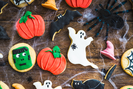 Homemade delicious gingerbread biscuits for Halloween in the form of Ghosts, Pumpkins, Bats and Cats on the rustic wooden tableの写真素材