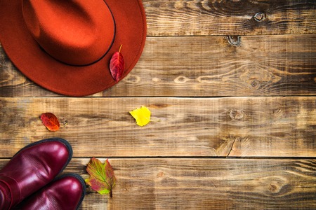 Stack of colorful warm autumn and winter clothes, top view, wooden rustic backgroundの写真素材