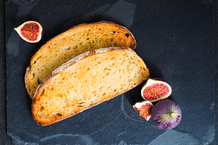 Toasts and fresh figs are ready for the healthy snack, on dark backgroundの写真素材
