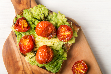 Healthy snack from white sourdough bread, such as avocado and roasted tomatoes toastsの写真素材