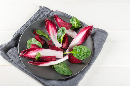 Red chicory, beetroot and spinach are in the plate before making halloumi salad