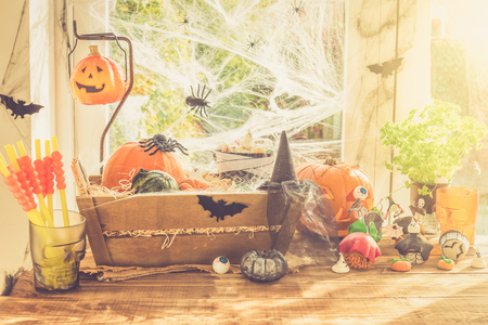 Table Set for Halloween Dinner with lots of Sweets, Pumpkin, Jack-o-Lantern, Cupcakes, Cookies, Bloody Jelly, Spiders, Web and other Halloween related staffの写真素材