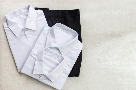 Back to school concept, school uniform such as white shirts and trousers on the light backgroundの写真素材