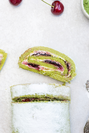 A delicate roulade of Matcha tea sponge, filled with fruity Morello cherry compote and creamの写真素材