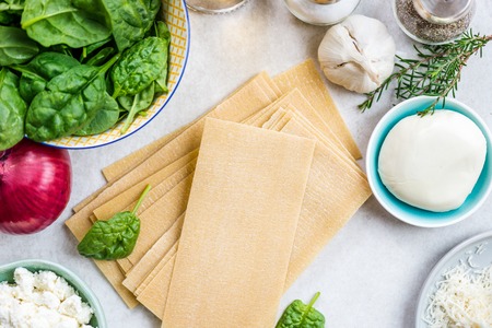 Ingredients for Vegetarian Spinach and Ricotta Lasagna, top view, grey background