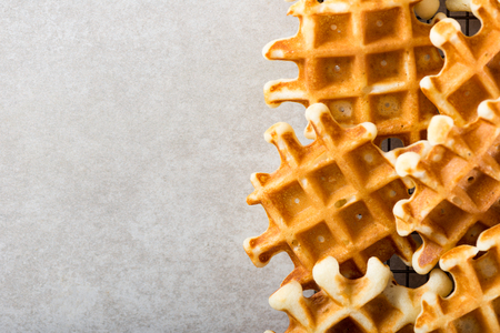 Traditional homemade belgian waffles on light background. Cosy family breakfast concept.  Flat lay, top view, copy space.の写真素材