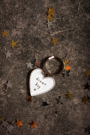 Keyring in the shape of heart and slogan DREAM BIG. Minimalist Concept of ambitions and reaching...