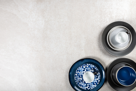 Empty Blue and Black Plates with Mugs on Grey Background, Top View, Copy Spaceの写真素材