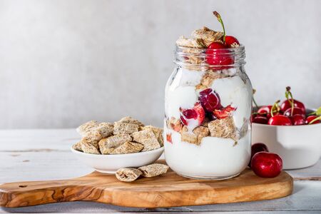 Healthy breakfast in the Jar. Bitesize shredded wheat with fresh cherry berriesの写真素材
