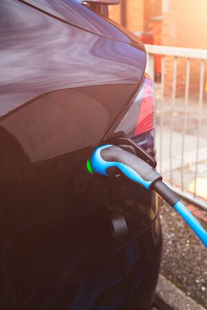 Charging modern electric car on the street car parking, sun flare effectの写真素材