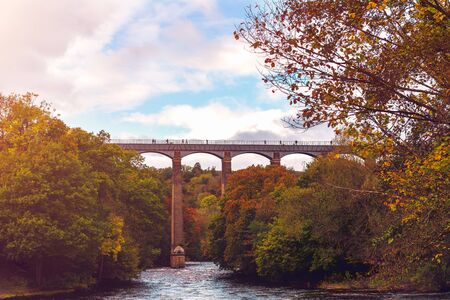 Pontcysyllte Aqueduct is a navigable aqueduct that carries the Llangollen Canal across the River Dee in the Vale of Llangollen in north east Wales, UK. Autumn Sceneryの写真素材