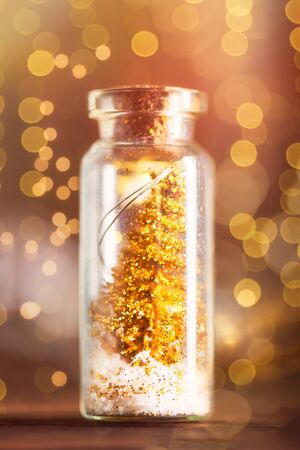 Miniature Gold Christmas Trees in Glass Baubles, which are in the form of Little Bottles, xmas postcard conceptの写真素材