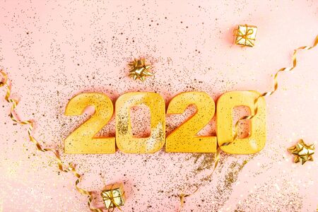 Happy New Year 2020. Digits 2020 are on pink background with glitter. Holiday Party Decoration or postcard concept with top view and copy space.の写真素材