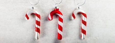 Christmas Tree Decorations made in the form of Glass Candy Canes on the grey background, top view,...