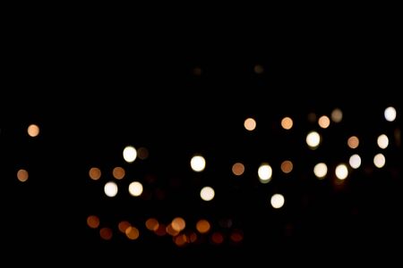 Abstract bokeh made from Christmas lights in the shop on black background. Holiday concept, overlay...