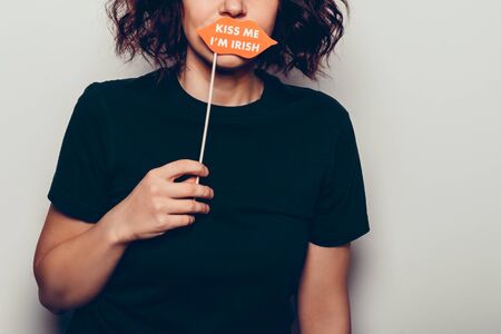 Young girl is preparing for the St Patricks Day party with photo booth props, Ireland traditional holiday, 17 March, kiss me im irish lipsの写真素材