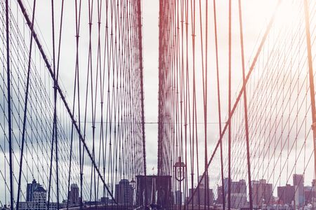 Details of the Brooklyn Bridge in New York City, USA. Toned image with sun light leakの写真素材