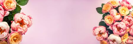 Fresh bunch of pink peonies and roses on pink background. Card Concept, pastel colors, close up image, copy space, long bannerの写真素材