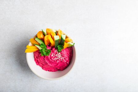 Homemade Beetroot Hummus made from Chickpeas and Beetroot in White Bowl with Carrot and Cucumber Sticks, light grey background. Healthy Vegetarian Detox Snackの写真素材