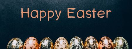 Natural Golden Speckled Easter Eggs of pastel colors with Happy Easter text on black background. Happy Easter card concept, minimalistic design, banner sizeの写真素材