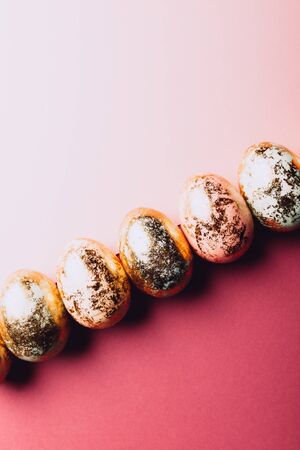 Natural Golden Speckled Easter Eggs of pastel colors on pink background. Happy Easter card concept, minimalistic design, copy spaceの写真素材