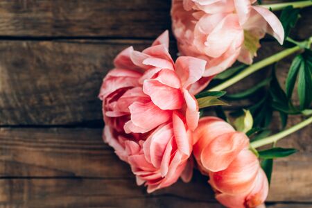 Fresh bunch of pink peonies and roses on wooden rustic background. Card Concept, pastel colors, close up image, copy spaceの写真素材