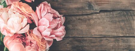 Fresh bunch of pink peonies and roses on wooden rustic background. Card Concept, pastel colors, close up image, copy spaceの写真素材
