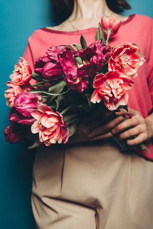Beautiful Bunch of Peony Style Tulips in the hands of young woman, spring holiday concept, copy space, present for mothers day from kidsの写真素材