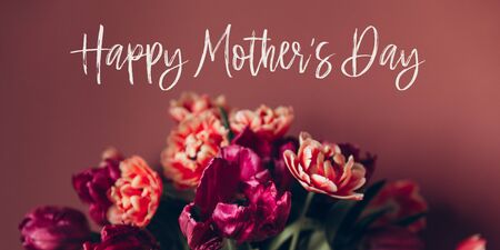 Happy Mothers day quote. Beautiful Bunch of Peony Style Tulips in the Vase on the dusty pink background, spring holiday concept, banner sizeの写真素材
