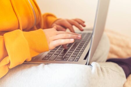 School age girl is home schooling using laptop during self isolation at her bedroom, online...
