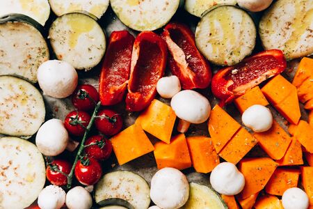 Healthy Detox Dinner from different vegetables such as aubergine, red pepper, cherry tomatoes, butternut squash, mushrooms. Slices of Raw vegetables prepared for the roasting, simple family mealの写真素材