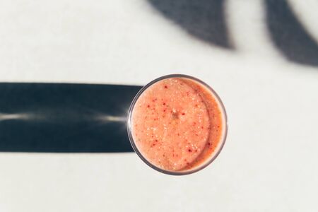 Pink Smoothie in the Bowl from Banana and Strawberries, strong shadows, Healthy summer breakfastの写真素材