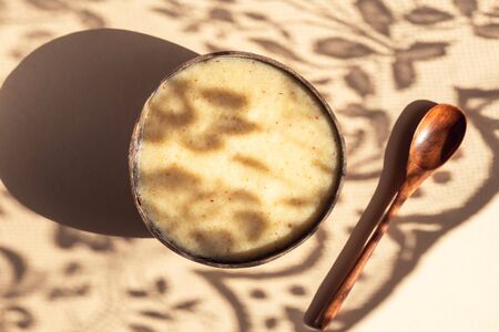 Healthy Smoothie from Banana, Pineapple and gluten free oats in the Coconut Shell Bowl, strong shadows. Healthy summer breakfast, top viewの写真素材