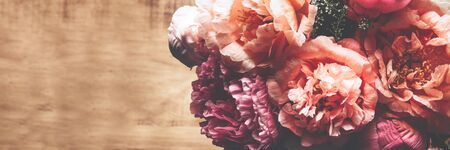 Abundance of Fresh bunch of Peonies Bouquet of different pink colors on dark wooden background. Card Concept, copy space for text, banner sizeの写真素材