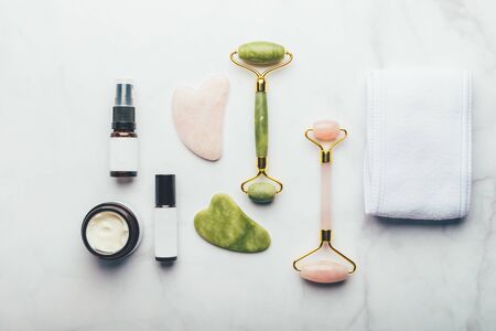 Jade face rollers and Gua sha stones for beauty facial massage therapy, Items for home treatment with Skin Care Anti-Aging Tools, Headband, Face Serum, Coconut Oil and Moisturiser Creamの写真素材