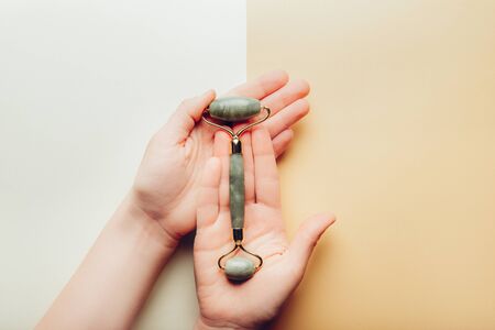 Hands are holding Jade face rolle for beauty facial massage therapyの写真素材