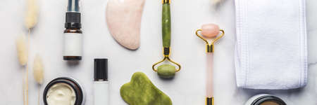 Jade face rollers and Gua sha stones for beauty facial massage therapy, Items for home treatment with Skin Care Anti-Aging Tools, Headband, Face Serum, Coconut Oil and Moisturiser Creamの写真素材
