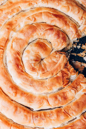 Filo Spinach and Feta Twist Pie in the iron pan after oven. Authentic Greek bakery. With spinach, mizithra and feta cheeses.の写真素材
