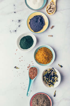 Variety of healthy food supplements such as blue matcha, butterfly pea flowers, collagen powder, spirulina powder, vitamins for vegans and vegetarians, flax and chia seeds,の写真素材