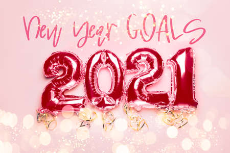 New Year Goals words and Balloon Bunting for celebration of New Year 2021 made from Silver Number Balloons on pink background. Holiday Party Decoration or postcard concept with xmas lightsの写真素材
