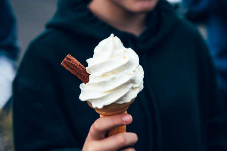 Soft vanilla ice cream with chocolate stick hold in hands