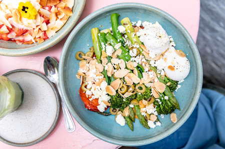Healthy Breakfast with poached eggs, roasted red pepper, tenderstem broccoli, asparagus, romesco...