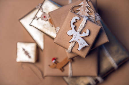 Pile of Gifts wrapped in recycled brown paper with handmade toppers, christmas background with...