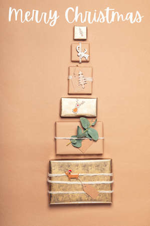 Merry Christmas postcard. Gifts wrapped in recycled brown paper with handmade toppers in form of...