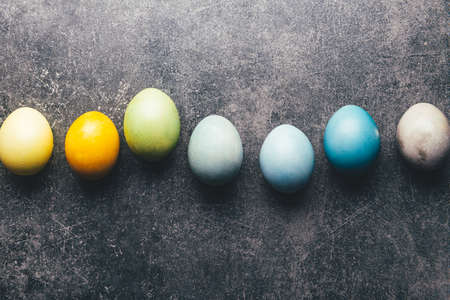 Easter eggs dyed in pastel colors with natural ingredients from red cabbage, onion, spinach,...